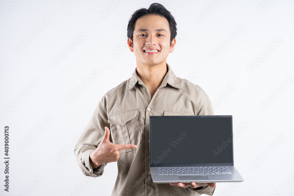 Portrait of male mechanic standing with laptop and pointing at it on white background Portrait of male mechanic standing with laptop and pointing at it on white background