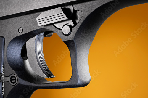 Trigger for a very large handgun with an orange and brown background