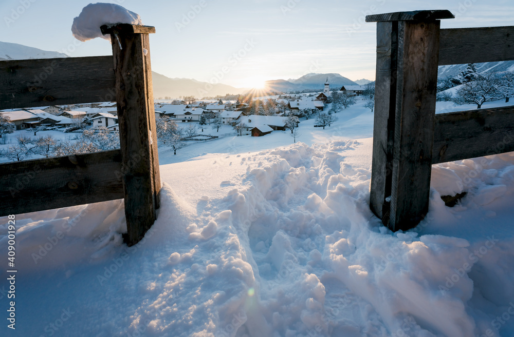 Snow covered alpine traditional Austrian village in winter landscape during sunset, Wildermieming, Tirol, Austria Snow covered alpine traditional Austrian village in winter landscape during sunset, Wildermieming, Tirol, Austria