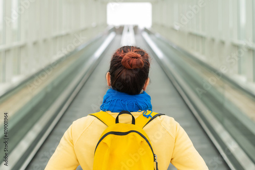 Rear view of a woman with a backpack moving on a travolator photo