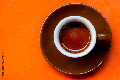 An espresso coffee in a brown ceramic cup