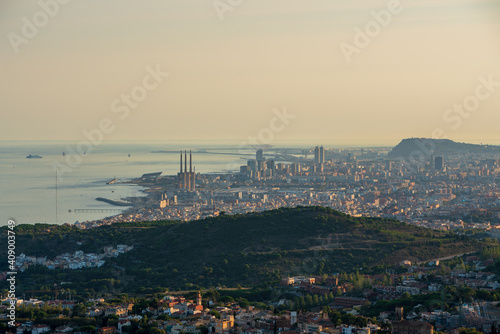 Panoramic view of the entire city of Barcelona and its surroundings. During sunset one day in late summer. We can see the Mediterranean sea completely flat. © Xavi Lapuente