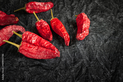 Red dry pepper. A group of hot dried chili peppers on a black charcoal surface.