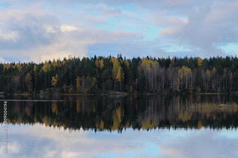Beautiful Ladoga lake with forest on bank and clouds reflections on water, Karelia.Autumn season landscape background. Adventure tourism. Travel in Russia concept. Beautiful places in Russia.