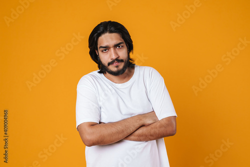 Upset indian man standing with folded hands isolated