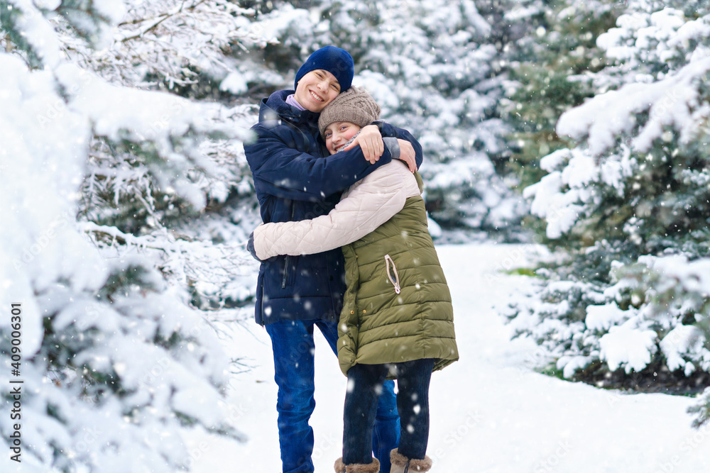 teens portrait in a winter forest, boy and girl, beautiful nature with bright snowy fir trees teens portrait in a winter forest, boy and girl, beautiful nature with bright snowy fir trees