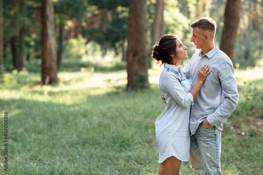 Cheerful young woman and man are hugging outdoors in summer park. Dating and romantic vacation. couple in love gently looking at each other on sunny day. Love and relationships between young people Cheerful young woman and man are hugging outdoors in summer park. Dating and romantic vacation. couple in love gently looking at each other on sunny day. Love and relationships between young people