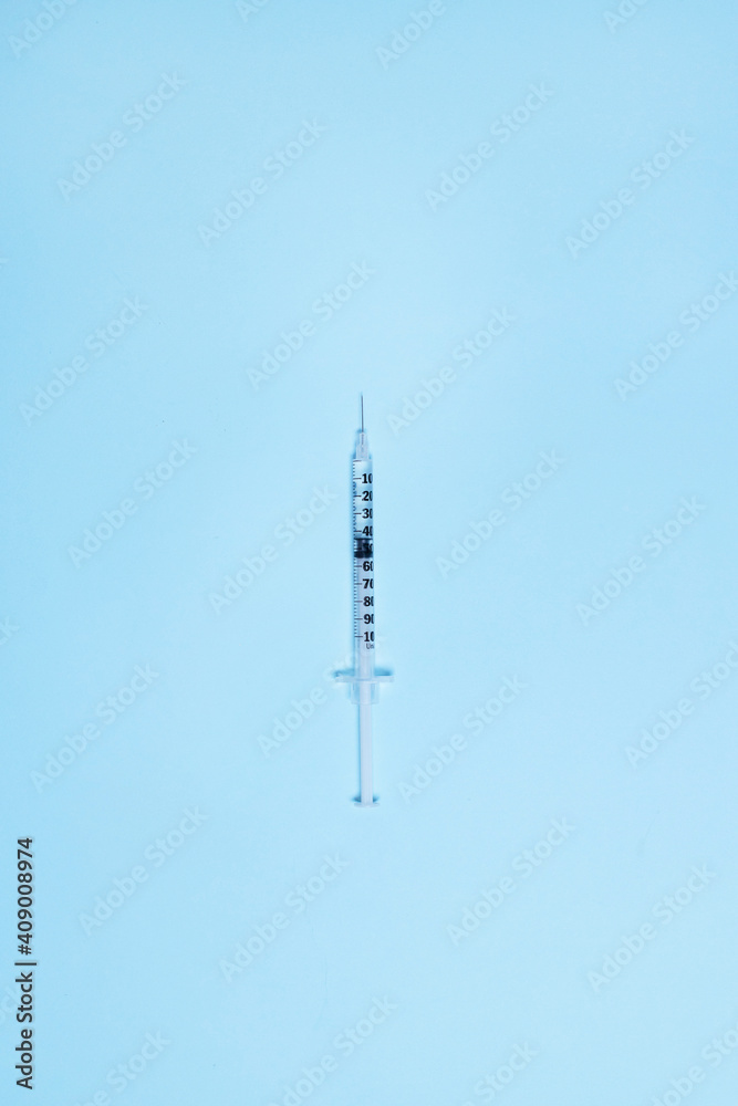 Syringe with medicine from glass vial on light blue background, flat lay. Vertical photo. Vaccination against influenza, covid 19, measles, coronavirus disease Syringe with medicine from glass vial on light blue background, flat lay. Vertical photo. Vaccination against influenza, covid 19, measles, coronavirus disease