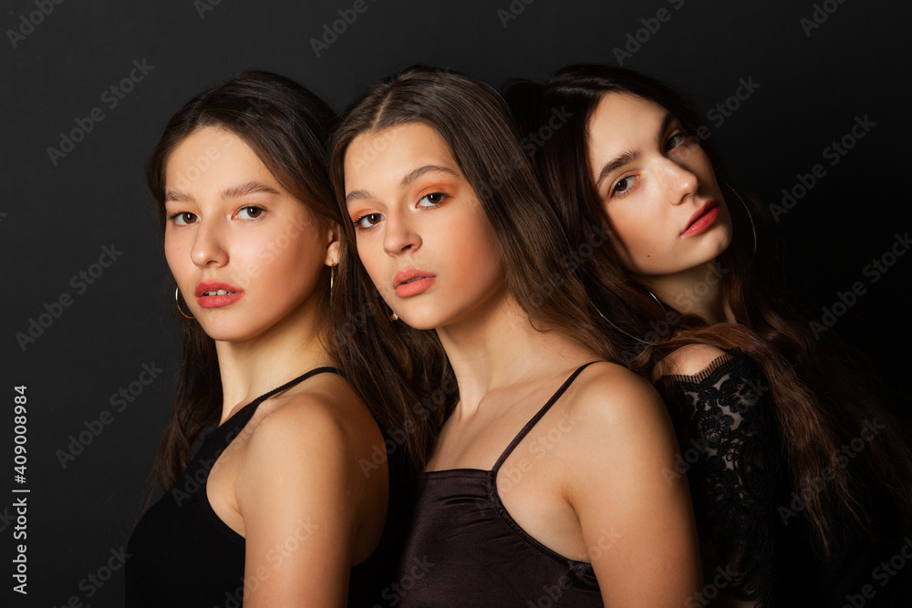 three beautiful young women with makeup and hairstyle on a black background three beautiful young women with makeup and hairstyle on a black background