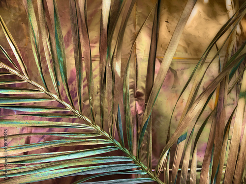 Tropical palm leaf, gold background.