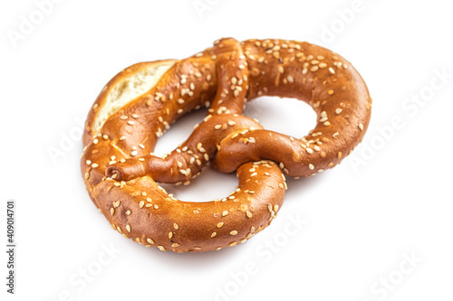 Golden-crusted brezel sprinkled with sesame seeds on a white background