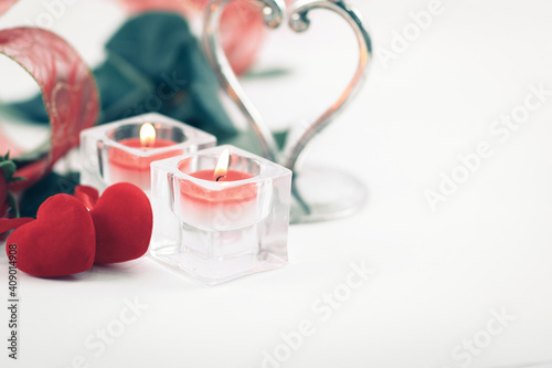 two candles and a beautiful rose on a white background