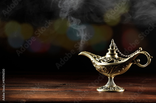 Magic lamp on a wooden table in the dark night 