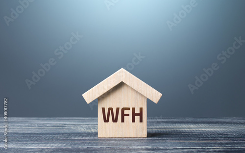 Wooden house figurine with abbreviation WFH (work from home). New normal. Strict requirements and restrictions policies in the work of company. Revision of basic business approaches. Staff teleworking photo