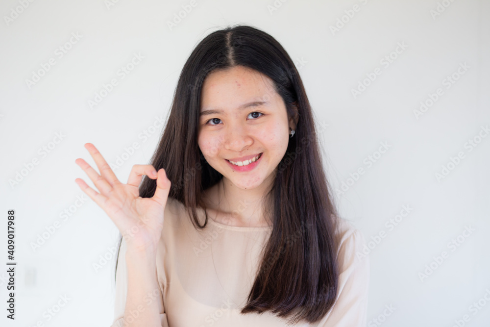 Happy young pretty woman standing over white background showing okay gesture. Happy young pretty woman standing over white background showing okay gesture.