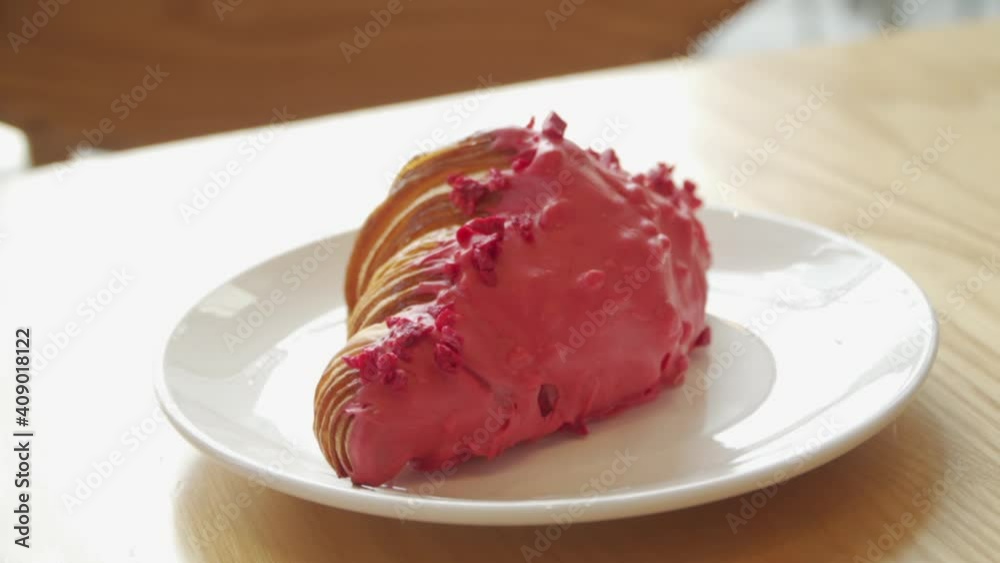 Fresh croissants with strawberry toppings in white plate on wooden table Fresh croissants with strawberry toppings in white plate on wooden table