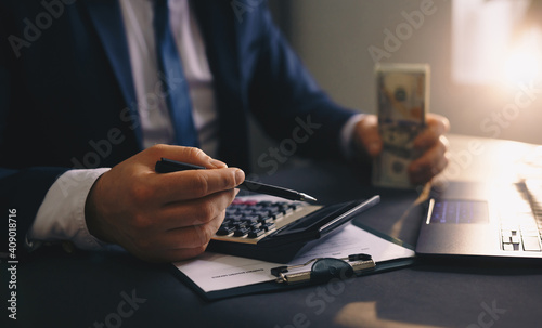 Businessman calculating dollars and writing in documents. Accounting and Taxes concept. 