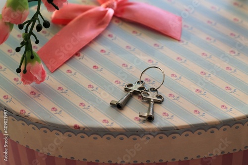 Small silver keys on a heart-shaped gift box.