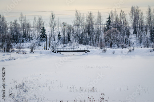 Rural winter landscape, bridge over the river. Russian hinterland.