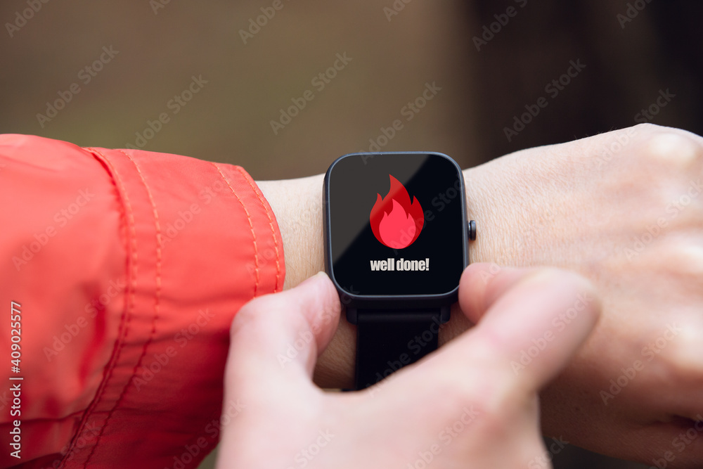 Fototapeta premium smart watch worn on the wrist seen up close with the calorie symbol