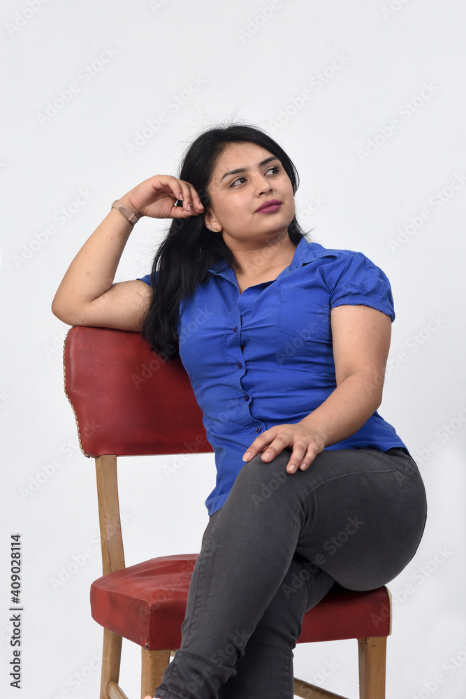 latin american woman sitting on a chair look up on white background