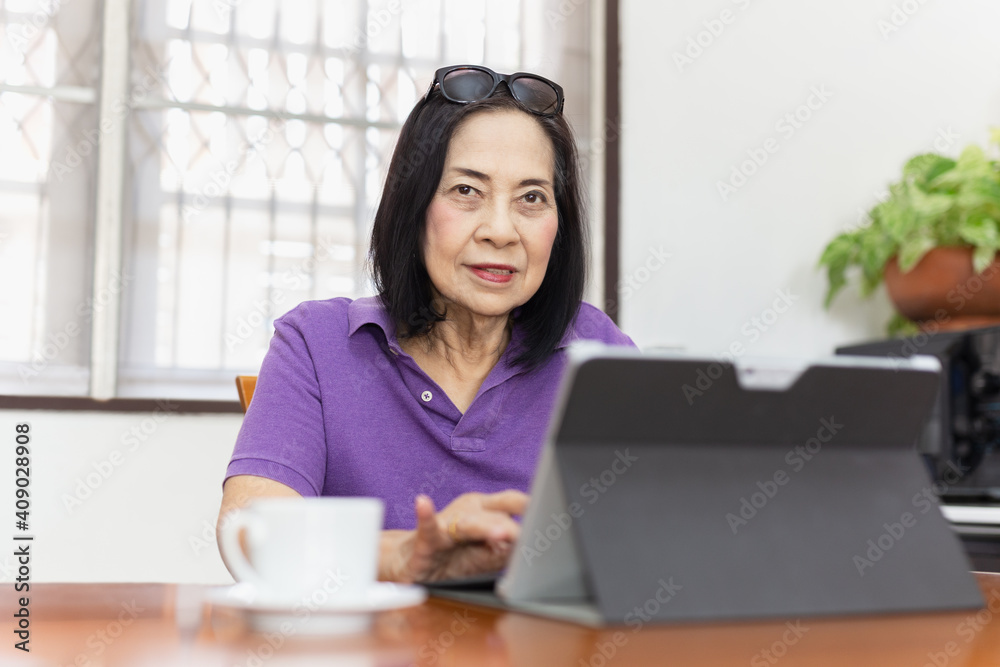 70s Old woman working on laptop computer at home. 70s Old woman working on laptop computer at home.