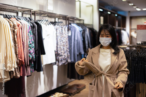 Young Asian woman choosing clothes in the store