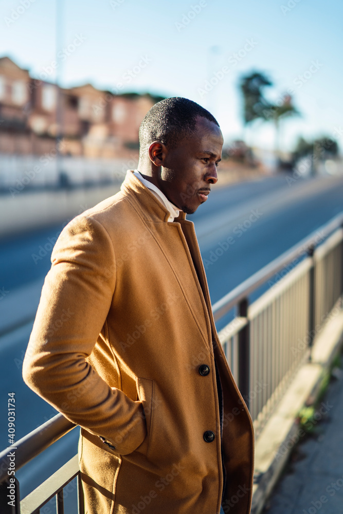 Chico negro con abrigo beige y traje Chico negro con abrigo beige y traje