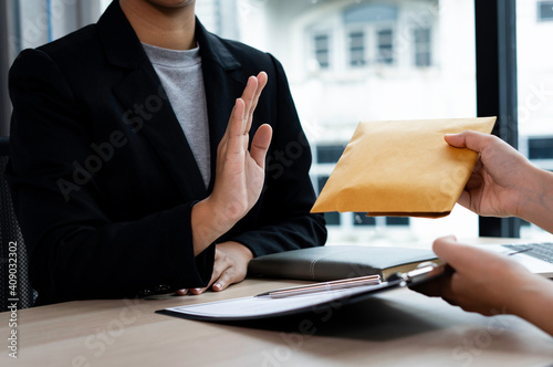Фотография Businesswoman or accountant is rejecting and resisting partner bribery deals in joint financial settlement, illegal anti-bribery ideas