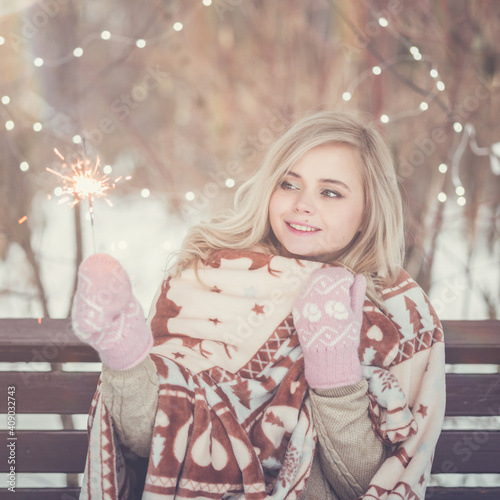 Portrait of young attractive celebrating woman holding sparkles.