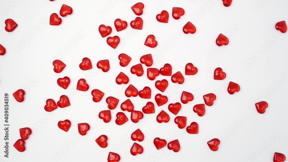 Hands holding figures in the form of hearts. They spill out on a white background in different directions and spin. Beautiful red hearts for Valentines Day. Gift for the holidays, declaration of love
