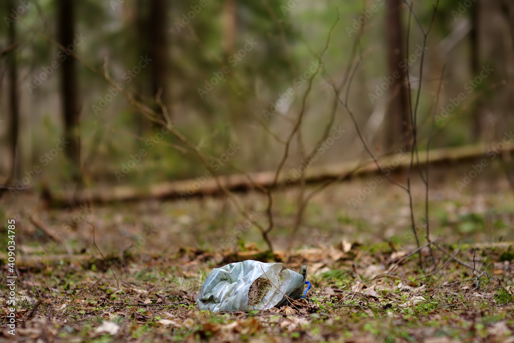 Old plastic bottle laying in the forest. Garbage in the woodland. Environmental contamination. Problems of recycling trash. Old plastic bottle laying in the forest. Garbage in the woodland. Environmental contamination. Problems of recycling trash.