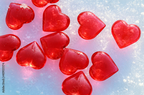 festive background with transparent red love symbols hearts lying on the snow