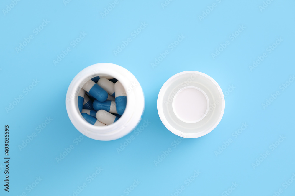 pills capsules with bottle isolated on blue background pills capsules with bottle isolated on blue background
