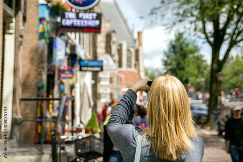 Photography Young woman takes pictures in vacation spent in Amsterdam with beautiful architecture and coffee shop