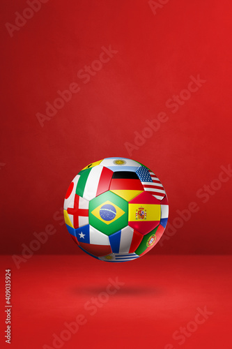 Football soccer ball with national flags on a red studio background