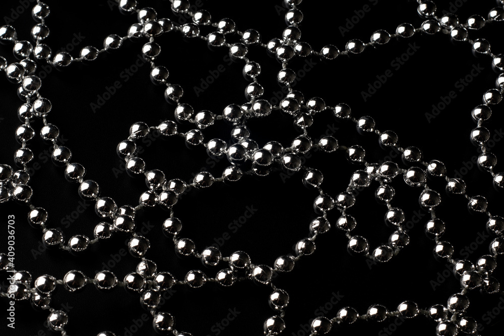 Sparkling silver beads in chaotic lines on a black polarized background