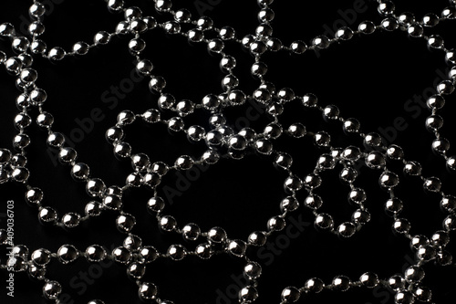 Sparkling silver beads in chaotic lines on a black polarized background