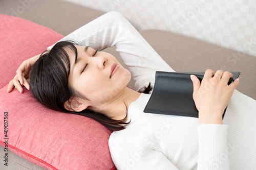 Woman sleeping while reading a book on the sofa