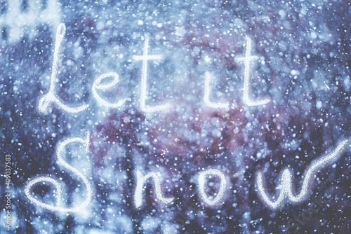 Let it Snow, written by hand on the snowstorm winter background, toned