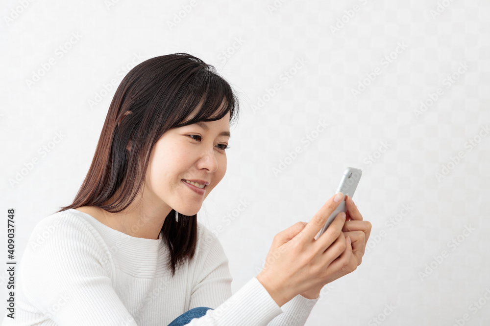 Woman sitting on the couch and holding a smartphone Woman sitting on the couch and holding a smartphone