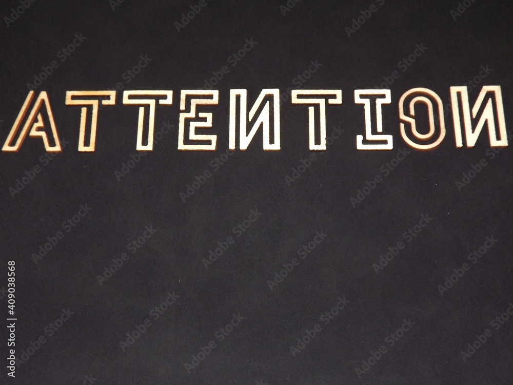 Obraz premium The word Attention is made of wooden letters on colorful backgrounds. High quality photo