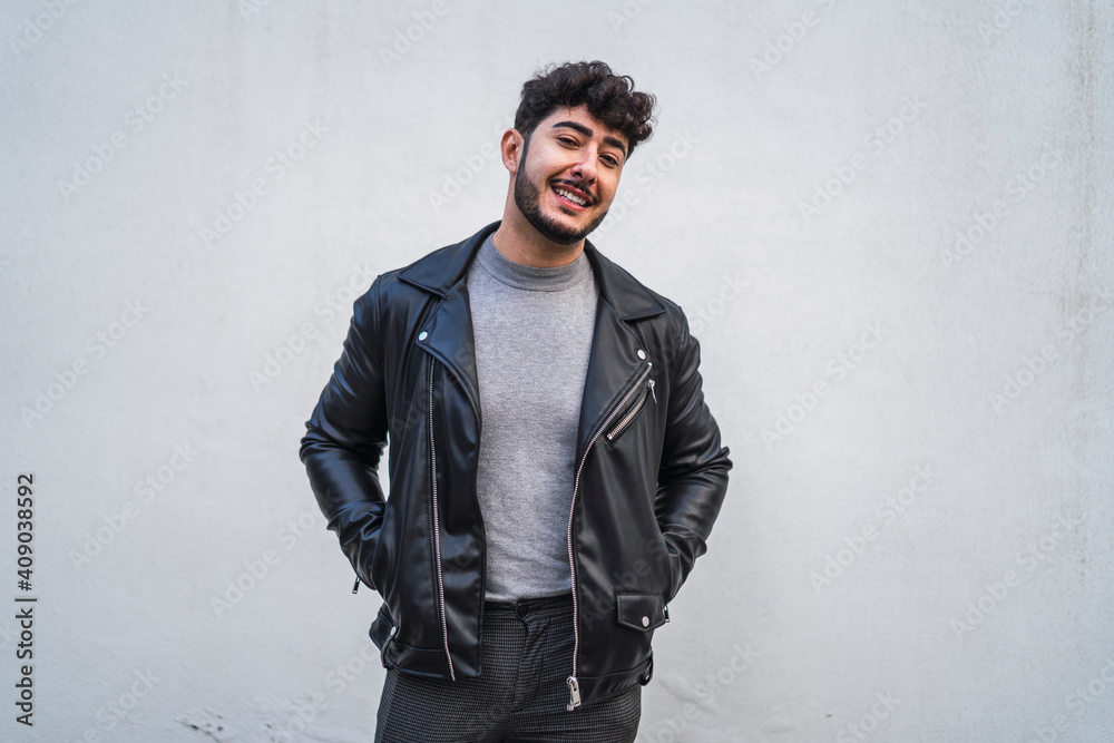 Fototapeta premium Chico joven moreno con cazadora de cuero sonriendo