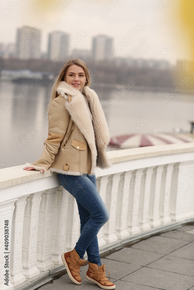 blond model girl in leather fur coat close up portrait on city architecture background blond model girl in leather fur coat close up portrait on city architecture background