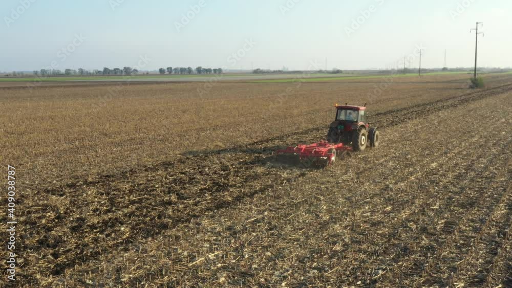 Above view shot of tractor, he is pulling machine, harrowing arable field, preparing soil for planting new crop next season. Above view shot of tractor, he is pulling machine, harrowing arable field, preparing soil for planting new crop next season.