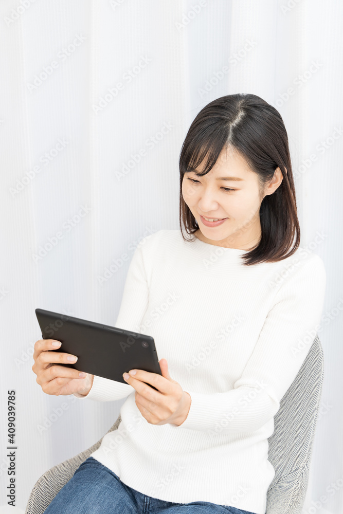 Woman sitting in a chair and holding a tablet Woman sitting in a chair and holding a tablet
