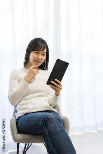 Woman sitting in a chair and holding a tablet