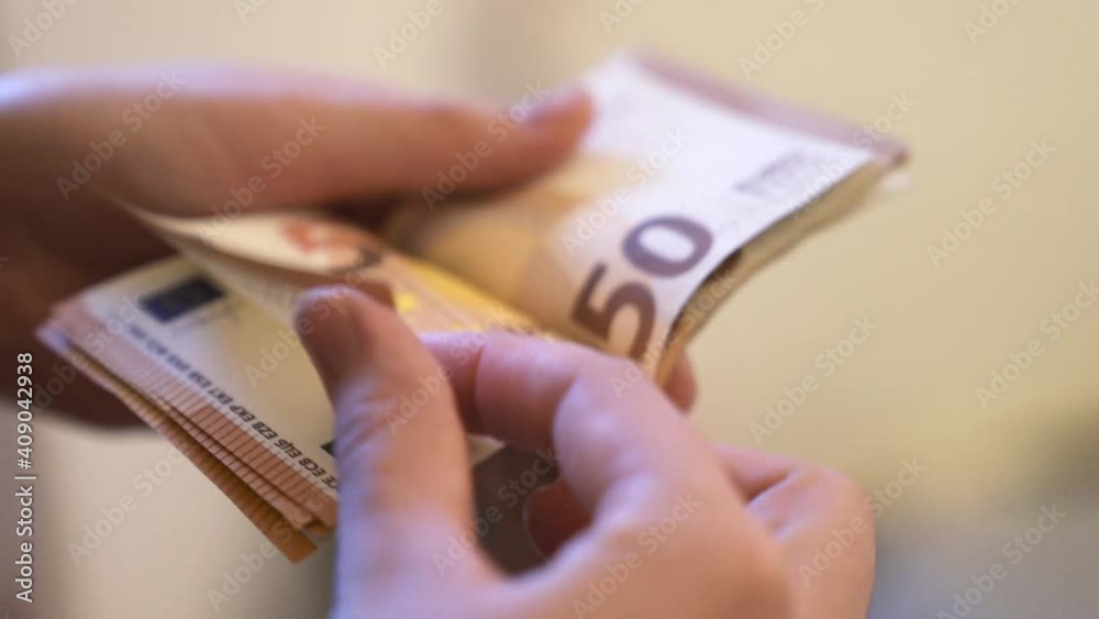 Close-up shot of a woman's hand counting euro bills