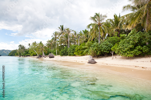Tropical island with a white sandy beach. Beautiful island with palm trees and blue sea