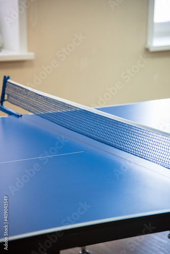 Blue table for tennis and stretched on it a tissue network